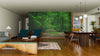 A modern living-dining room with wood floors and minimalist furniture features the Green Beautiful Forest Wall Mural, bringing a calming, natural vibe to the space complete with seating, a dining table, and globe pendant lights.