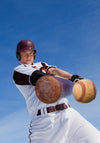 The Home Run Hit Wall Mural shows a baseball player in a white and maroon uniform swinging at the ball under a clear blue sky—captured from below, it's perfect for peel and stick or matte canvas textured wall decor.