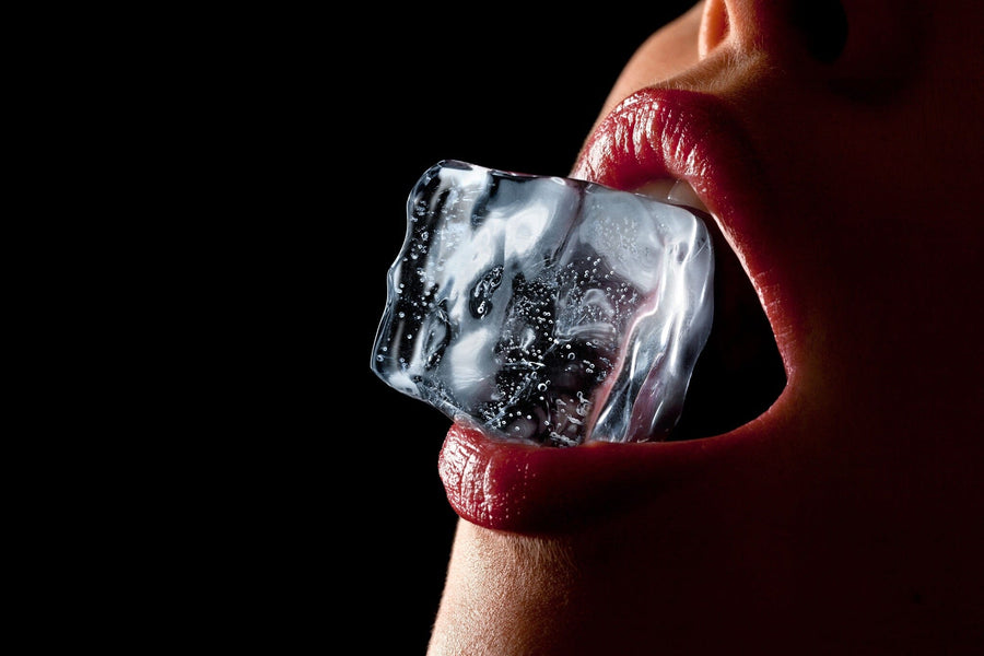 A close-up shot of a person holding a transparent ice cube between glossy red lips against a black backdrop creates an impact as striking as the Sexy 4 Wall Mural, with light reflections highlighting the ice's texture.