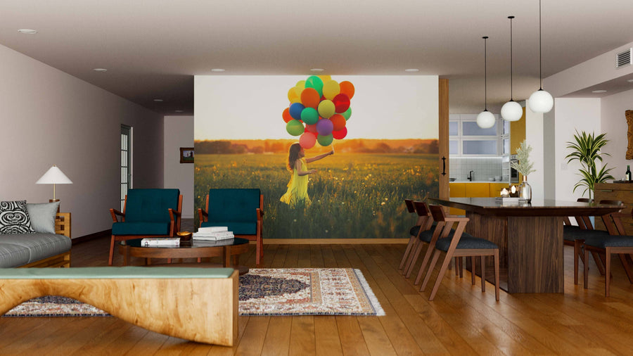 A modern open-plan living and dining room with wood floors features the Beautiful Girl in a Field Wall Mural, showing a girl in a yellow dress holding balloons at sunset, adding vibrant, playful flair to the space.