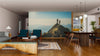 A modern open-plan living and dining area with wooden floors, teal chairs, a large table, and the Female Hikers Wall Mural creates a stylish, cozy space brightened by natural light.
