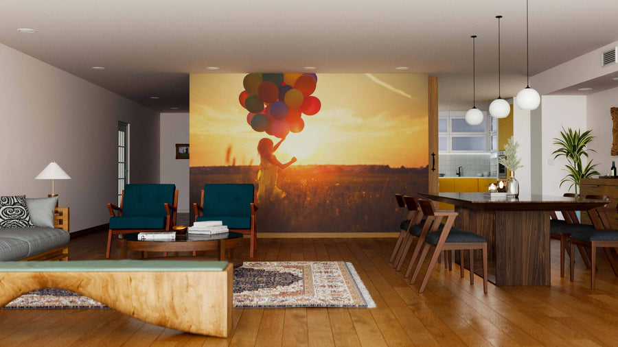 A modern living and dining area with wooden floors, green chairs, pendant lights, a wooden dining table, rugs, and a visible kitchen is styled with the Happy Girl Wall Mural showing a child holding balloons at sunset.
