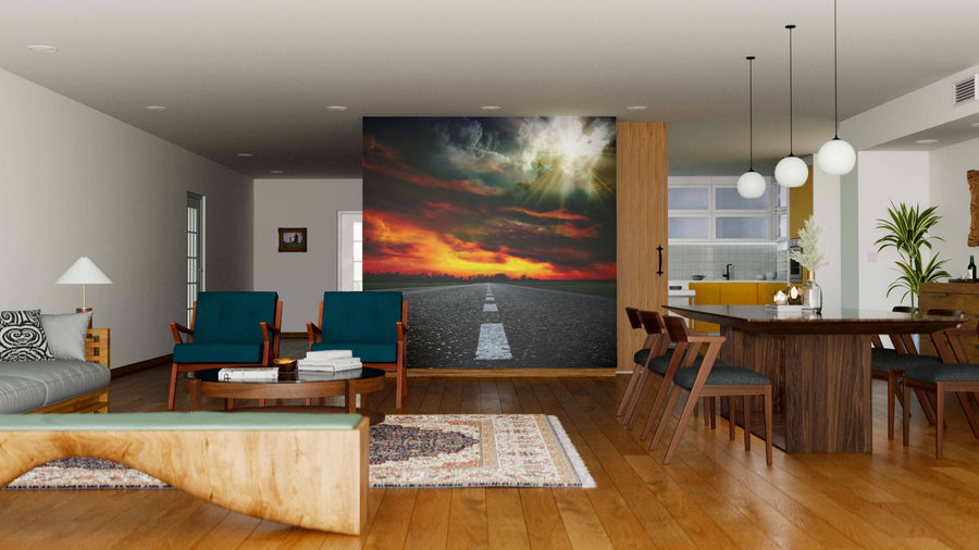 A modern open-plan living and dining room with wooden floors, mid-century furniture, and pendant lights features a "Summer Landscape with Old Road Wall Mural," adding vibrant color and depth with its dramatic sunset sky.