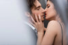 A man and woman embrace closely, eyes closed and about to kiss, the woman gently touching his face. Both are dressed formally, framed by soft lighting—perfectly captured in the Intimate Moment Wall Mural for a romantic touch.