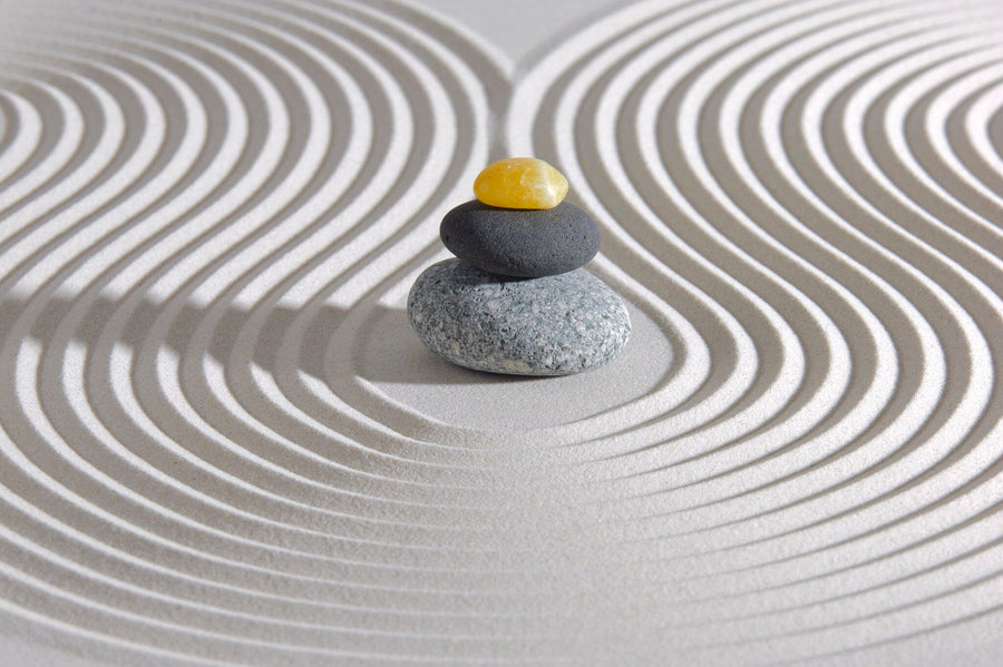 A modern open-plan living and dining room with wood floors, teal chairs, and pendant lights features the Japan Zen Garden Wall Mural of stacked stones on raked sand, creating a tranquil zen-like focal point.