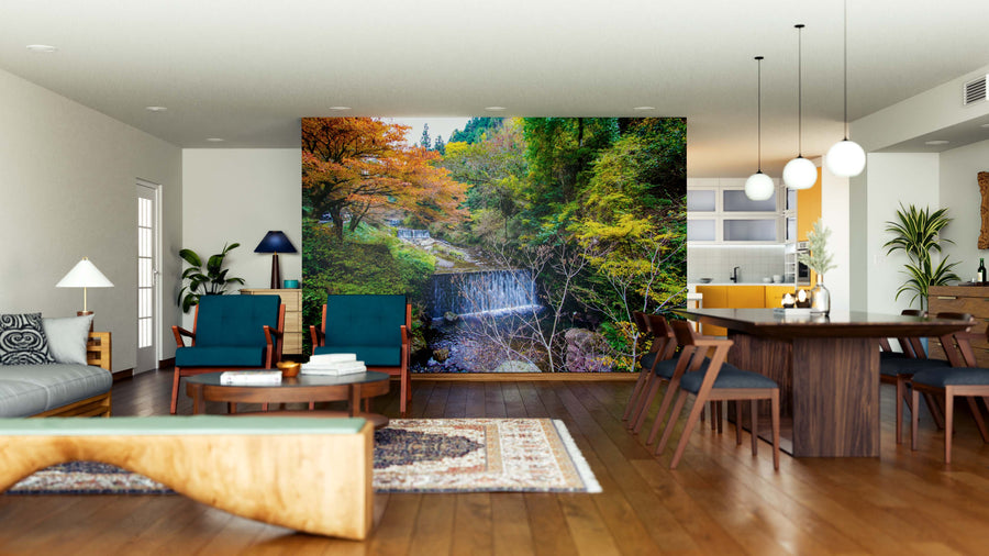 A modern open-concept living and dining room with wooden floors, blue furniture, pendant lights, and the Kyoto During Fall Wall Mural brings vibrant autumn nature scenery into the stylish interior.