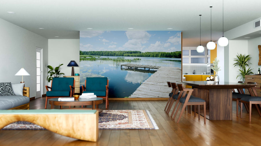 A modern open-plan living and dining room with wood floors, blue chairs, a large dining table, and the vibrant Lakeside Pier Wall Mural creates a stylish yet cozy atmosphere perfect for relaxing or entertaining.