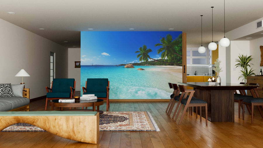 A modern living-dining area with wooden floors, stylish furniture, and the Anse Lazio Beach Wall Mural—depicting blue water, white sand, and palm trees—for an inviting and relaxing atmosphere.