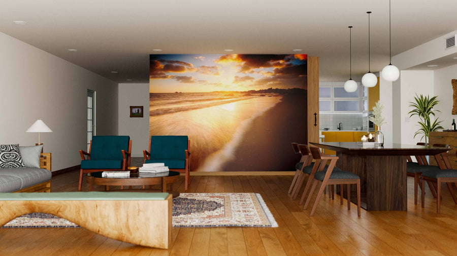 A modern living and dining area features wooden floors, matching furniture, two teal armchairs, a sofa, a six-seat dining set, rug, pendant lights, and an Australian Beach Wall Mural accenting one wall.