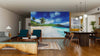 A modern living-dining room with wooden floors and stylish furniture features the Beach at Mahe Island Wall Mural, showcasing palm trees, blue sky, and ocean waves for an open, airy, and relaxing indoor atmosphere.