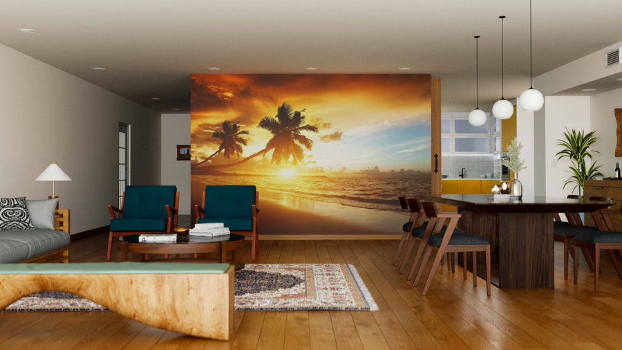 Modern living-dining room with wooden floors, teal armchairs, and a dark dining set. The Beach of Caribbean Sea Wall Mural creates a vibrant focal point, making the bright space inviting and perfect for relaxation.