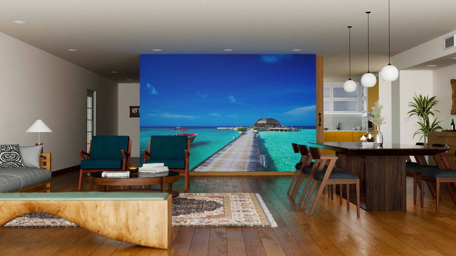 A modern living and dining area with wooden furniture and neutral tones is enhanced by the Beautiful Beach at Maldives Wall Mural, a large peel and stick mural that brings vibrant turquoise water and tropical scenery into the stylish space.