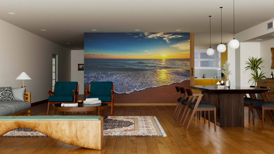 A modern open-plan living-dining room with wood floors features teal armchairs, a rustic dining table, and the Beautiful Cloudscape Over the Sea Wall Mural, bringing serene natural beauty. Spherical pendant lights illuminate the dining area.