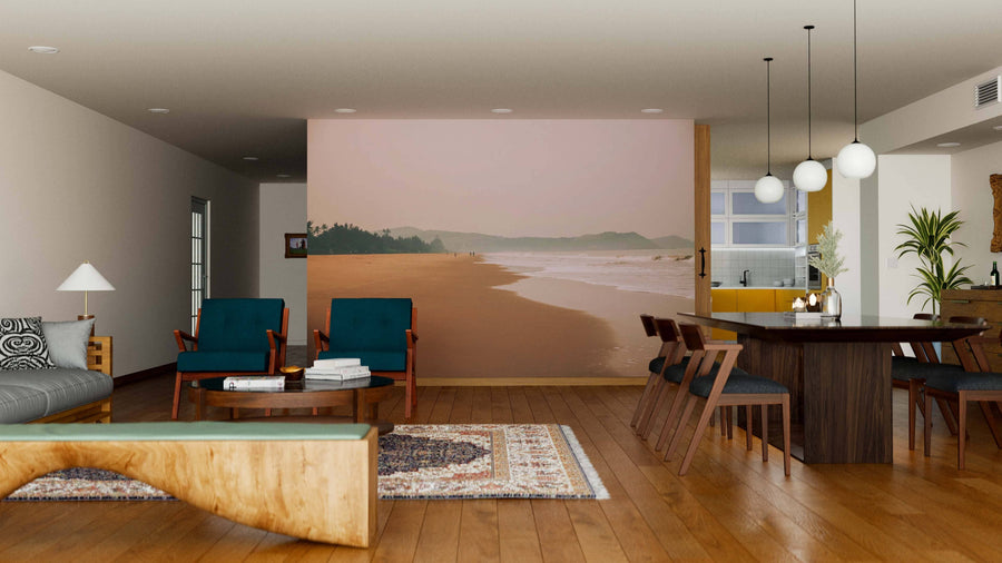 A modern living-dining room with wooden floors, teal armchairs, a gray sofa, and the Beautiful Foggy Seashore Wall Mural. A wooden dining table for six, globe pendant lights, and cozy decor complete the inviting space.