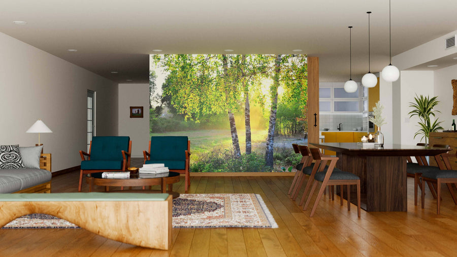A modern living-dining area with wood floors, mid-century furniture, globe lights, and a large Birch Trees In A Summer Forest Wall Mural creates an open, inviting space where sunlight blends nature with contemporary style.