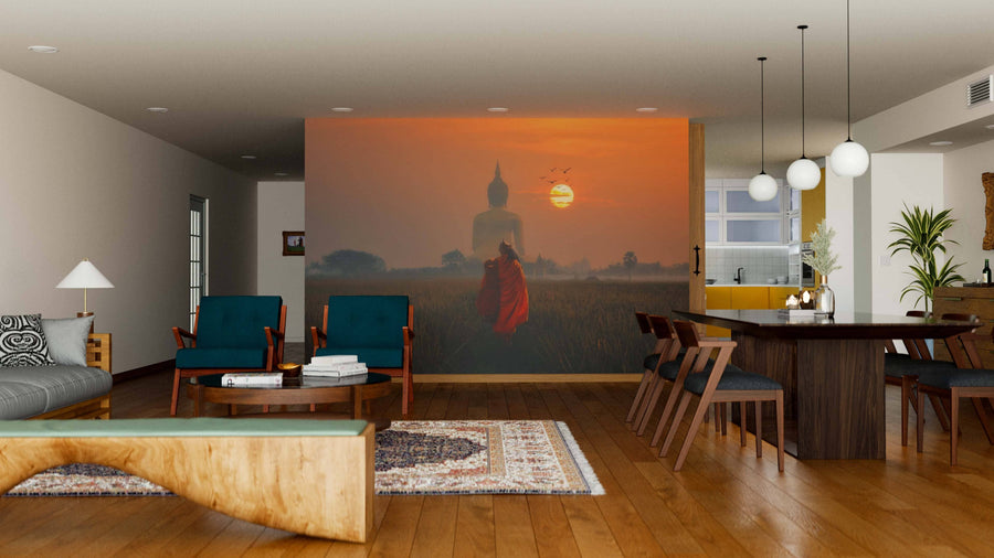 A modern living-dining area features wooden floors, mid-century furniture, and a rug. The Buddha Wall Mural depicts a Buddha statue at sunset over grassy fields. Round pendant lights hang above the dining table; the kitchen is visible in back.