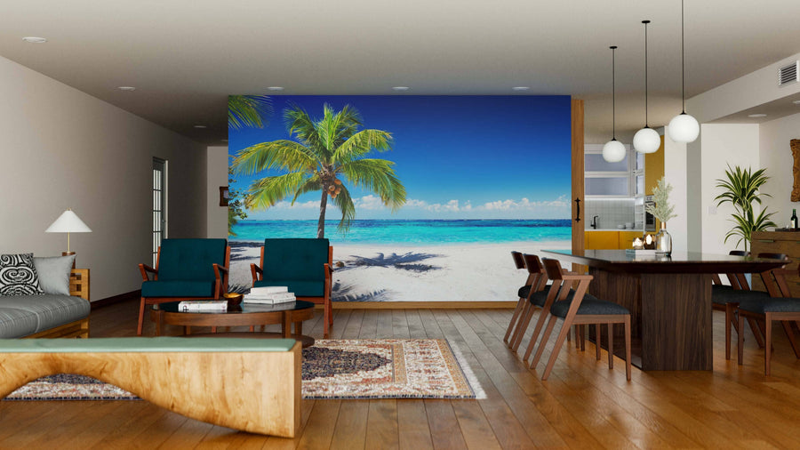 A modern living-dining room with wooden floors and mid-century furniture features the Coral Beach With Palm Tree Wall Mural, adding a vibrant tropical view that contrasts beautifully with the cozy indoor setting.