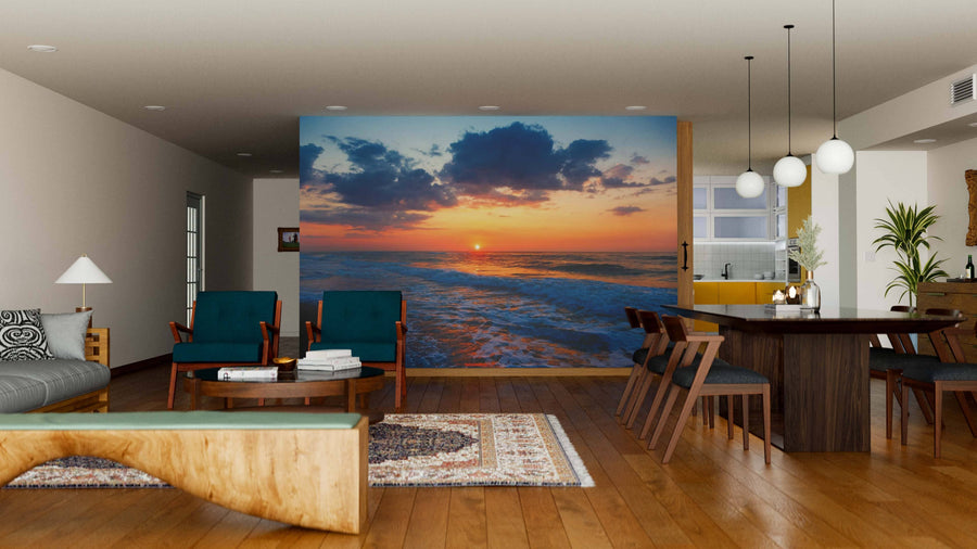 A modern open-plan living and dining room with wooden floors and mid-century furniture features the Empty Beach Wall Mural as a striking focal point, while warm lighting enhances the inviting atmosphere.