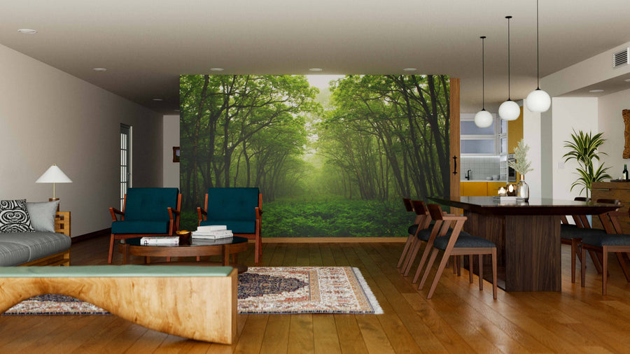 A modern living and dining room with wood furniture and green chairs features the Forest Mystic Way Wall Mural, bringing a lush outdoor feel. Pendant lights above the table and rugs on the wooden floor make the space bright and inviting.