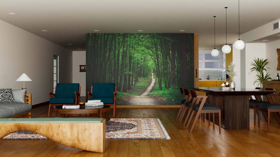 Modern open living-dining space with wood floors, gray sofa, blue chairs, round coffee tables, dining set, pendant lights, and kitchen. A Long Pathway in Green Forest Wall Mural adds nature-inspired style to the room.