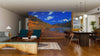 A modern living-dining room with wood floors and a large table features the Maroon Lake Panoramic View Wall Mural as a scenic focal point, adding vibrant color and easy-to-update style to the open space.