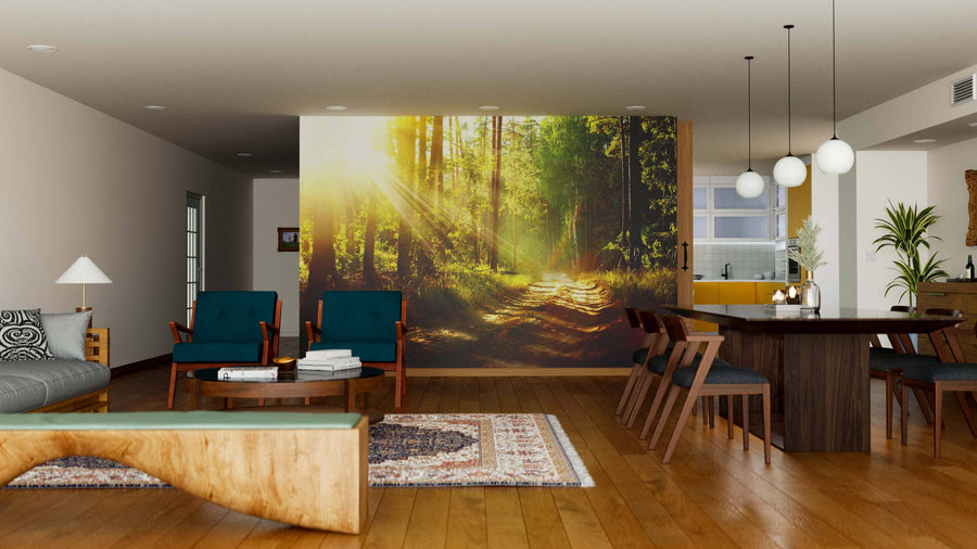 A spacious living-dining room with wood floors, teal armchairs, and globe pendant lights features a Misty Old Forest with Sun Rays Wall Mural, creating a serene vibe. An open layout reveals the kitchen in the background.