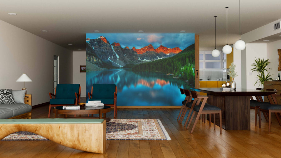 A modern open-plan living and dining area with wood flooring, stylish furniture, and a Moraine Lake Sunrise Banff Canada Wall Mural featuring sunset peaks reflected in the lake, creating a striking focal point in the space.