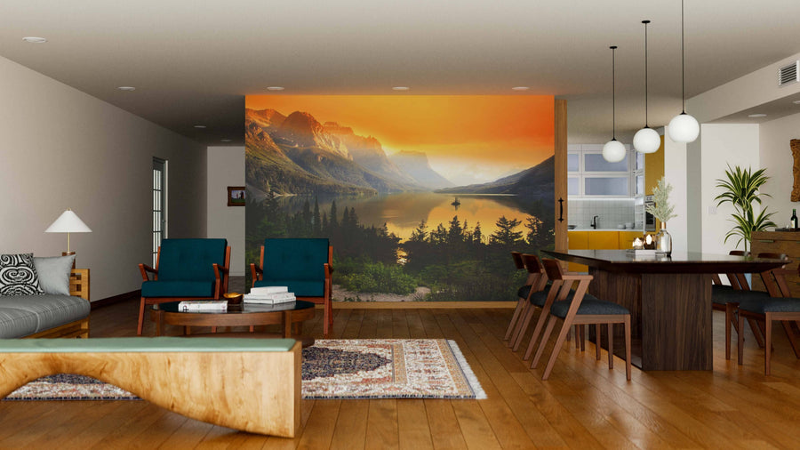 A modern open-plan living and dining room with wooden floors, mid-century furniture, rugs, and a large Mountains Over Saint Mary Lake Wall Mural at sunset creates a warm, inviting atmosphere.