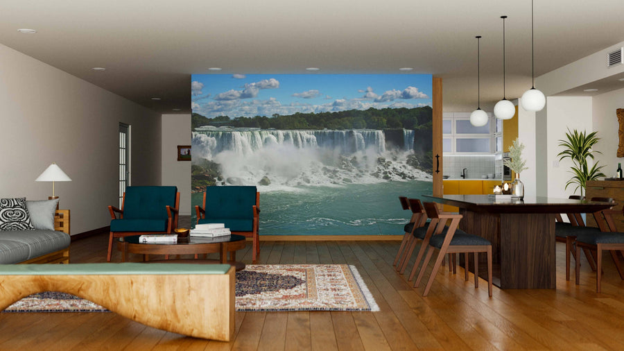 A modern living and dining room with wooden floors and mid-century furniture features the Niagara Falls Wall Mural, adding a scenic waterfall view. Sofas, armchairs, a dining table, and hanging lights complete the space.