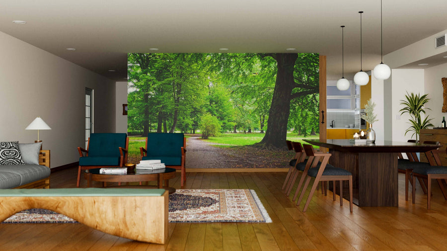 A modern living-dining room with wooden floors, teal chairs, and a sofa features the Park in Autumn Time Wall Mural, bringing nature indoors. Globular pendant lights add elegance above the spacious dining table.