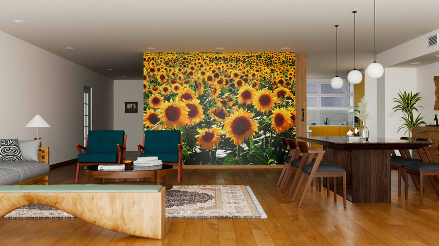 A modern open-plan living and dining room features the Photograph of Sunflower Field Wall Mural. Wooden floors, dark wood furniture, green upholstered chairs, and pendant lights create a cozy, inviting atmosphere.