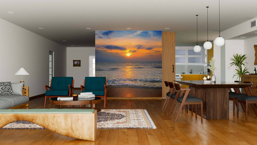 A modern open living and dining area with wood floors, stylish furniture, and a Sea and Beautiful Sunrise Wall Mural featuring orange clouds and calm ocean waves, serving as a serene focal point in the contemporary space.