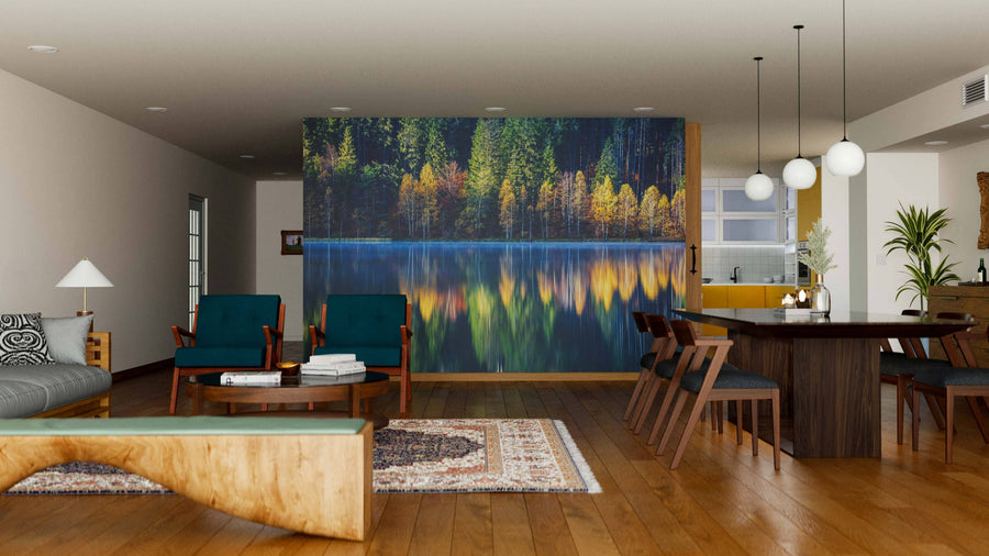 A modern open-plan living and dining room features wooden floors, teal armchairs, a wood bench, dark dining chairs, globe pendant lights, and the stunning Still Lake in Autumn Wall Mural.