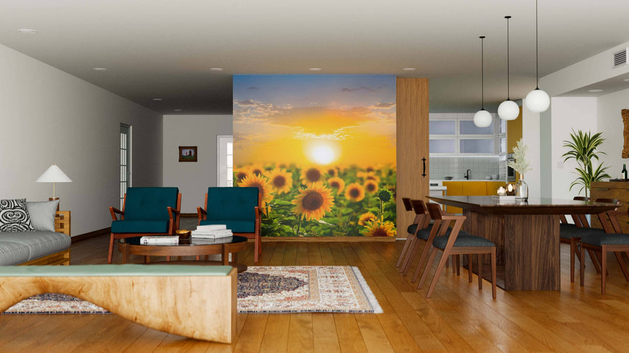 A modern open-plan living and dining area with wood flooring, teal chairs, a wooden dining table, and the Sundown on Sunflower Field Wall Mural separates the space from a vibrant yellow kitchen in the background.