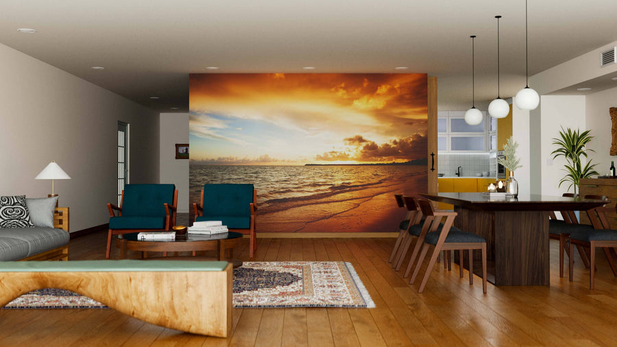 Modern living-dining room with wooden floors, teal chairs, and a large “Sunrise in the Ocean” wall mural. Pendant lights hang over a dark table. A gray sofa, rugs, and accents complete this cozy space.