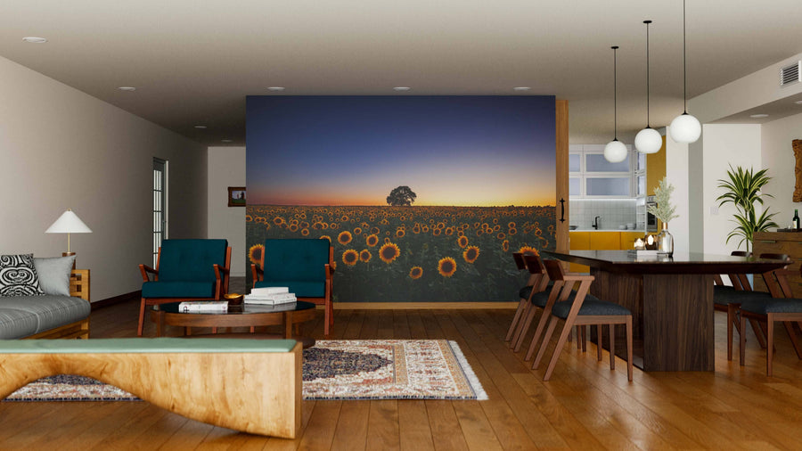 A modern open-plan living and dining room with wooden floors, stylish furniture, and the Sunset Over Sunflower Field Wall Mural as a peel and stick accent, creating a warm, artistic focal point in the cozy, well-lit space.