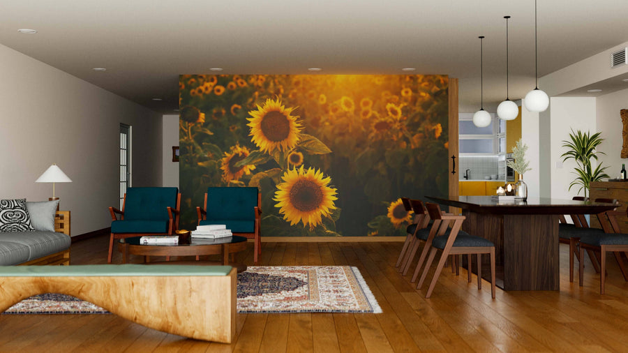 Modern living and dining area with wooden floors, blue and wooden furniture, a rug, and pendant lights. The space features the Sunshine in Sunflower Field Wall Mural, infusing vibrant color and a cozy golden glow as the room’s focal point.