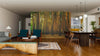 A modern open-plan living and dining area with wooden floors, mid-century furniture, and a large dining table is enhanced by the Tall Thin Forest Trees Wall Mural, bringing a serene, natural atmosphere to the stylish space.
