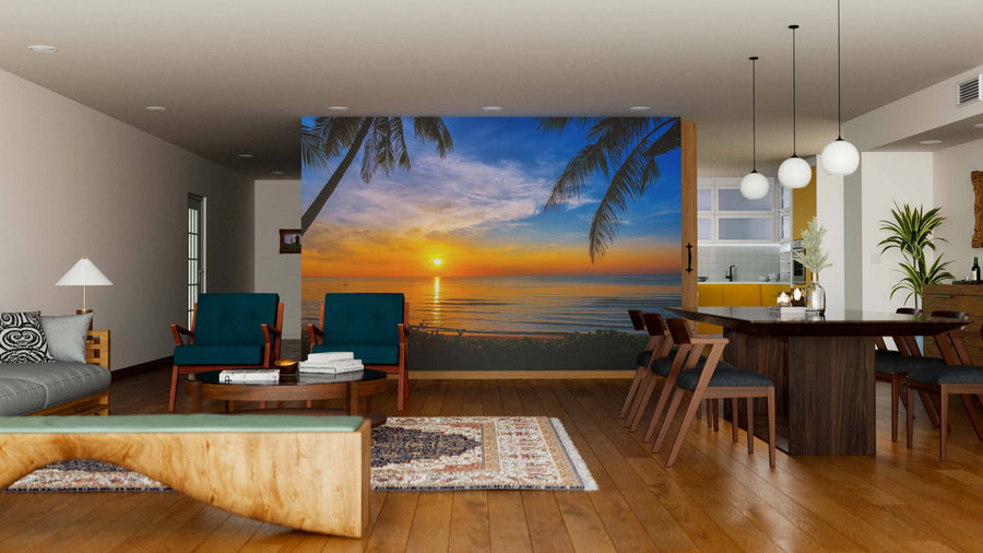 A modern living-dining room features wooden floors, contemporary furniture, pendant lights, and a large Tropical Nature Landscape Wall Mural depicting a beach sunset with palm trees, creating a relaxing, nature-inspired atmosphere.