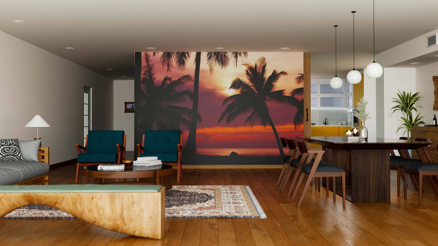 A modern living and dining room with wooden floors, teal armchairs, a rug, and the Violet Sunset Wall Mural adds warmth and color. The dining area includes a dark table and globe pendant lights.