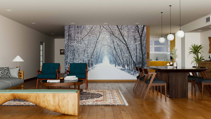 A spacious living and dining area features wood floors, dark teal chairs, a large dining table, and the Winter Forest Alley with Trees Wall Mural. Modern lighting, cozy furnishings, decor, and indoor plants complete the inviting space.