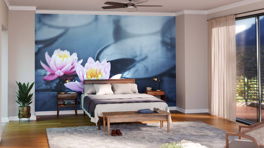 A modern bedroom showcases the Lotus Blossoms Wall Mural behind the bed, paired with wooden furniture, a gray rug, wood floors, a plant, and a glass door with beige curtains that let in natural light.