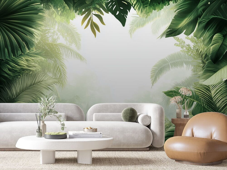 A modern living room showcases the "Lush Oasis Wall Mural" with lush green tropical leaves. It includes a white curved sofa, a round plant-adorned coffee table, and a tan leather chair. Soft lighting enhances the serene, nature-inspired atmosphere.