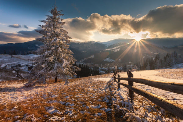 Sunlight casts a radiant glow on a snowy mountain landscape – Peel and Stick Wall Murals