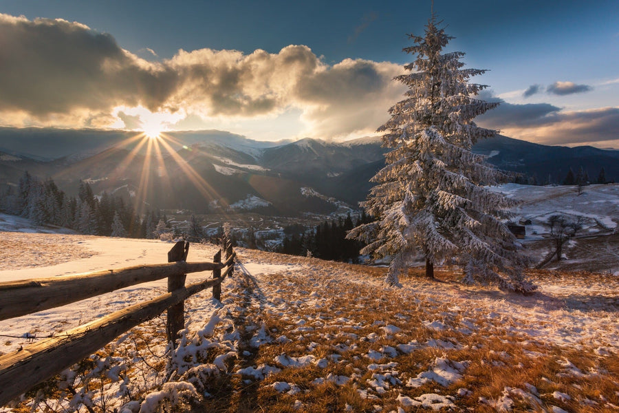 Sunlight casts a radiant glow on a snowy mountain landscape – Peel and Stick Wall Murals