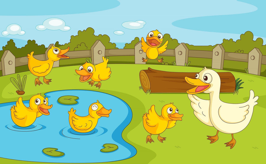 The Ducklings at Play Wall Mural features a white mother duck and five yellow ducklings outdoors, with two in a pond, three on grass, a wooden fence, green bushes, and a blue sky with clouds in the background.