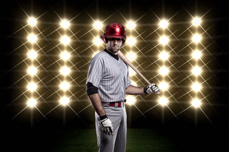 Bring the excitement of the game to your space with the "Game Face On Wall Mural," featuring a baseball player in a gray pinstriped uniform and red helmet, bat poised, under dramatic stadium lights. Matte canvas texture, peel and stick for easy application.