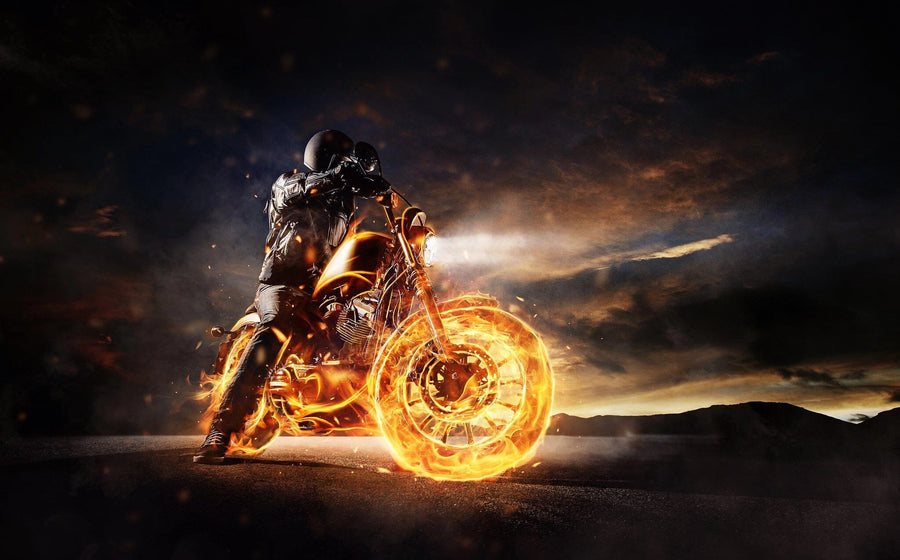 A motorcyclist in a leather jacket and helmet rides on fiery wheels along a dark road, under a dramatic sunset sky. This intense scene mirrors the thrill captured by Deposit photo's Motor 10 Wall Mural.