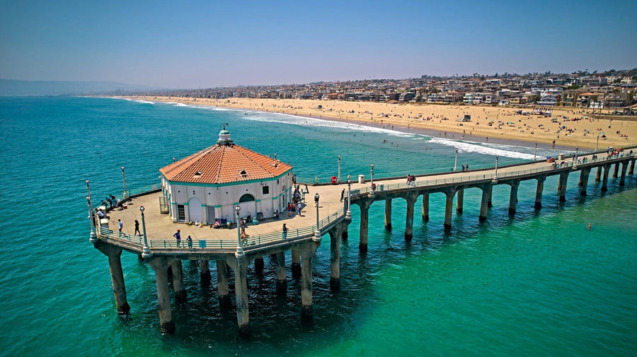 Transform your space with the Ocean View from Pier Wall Mural, a peel and stick wallpaper featuring a long pier, round red-roofed building, turquoise water, and a sandy beach. Easy to apply and remove for instant room refresh.