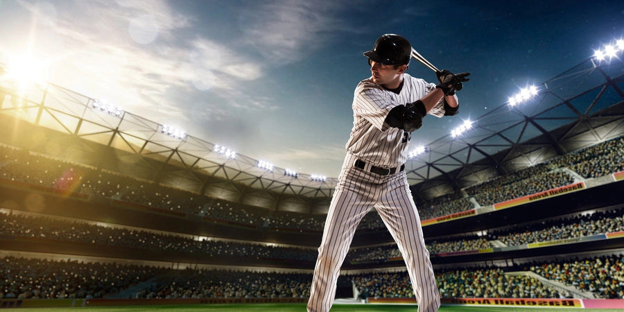 The Ready to Bat Wall Mural features a baseball player in a black helmet and pinstripe uniform, poised to bat in a stadium at sunset—perfect as a peel and stick canvas-textured mural for any sports fan’s space.